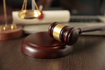 Judge gavel, scales of justice and law books in court