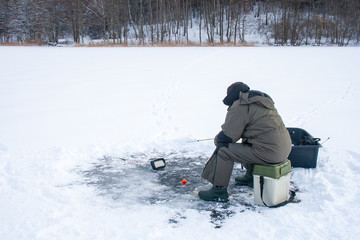 Fototapeta na wymiar Fishing on a frozen lake in winter with sonar