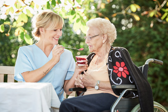 Pflegerin hilft Seniorin beim essen