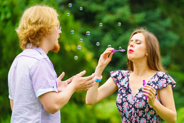 Fototapeta premium Couple blowing soap bubbles, having fun