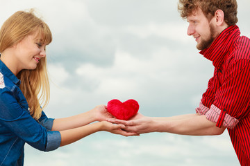 couple in love holds red heart outdoor