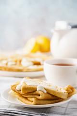 Homemade lemon crepes with custard sauce and tea.