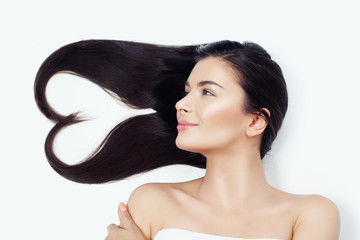 Young woman with heart of healthy curly hair on white