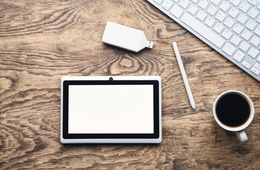 Tablet computer keyboard and coffee on wooden desk. Business concept