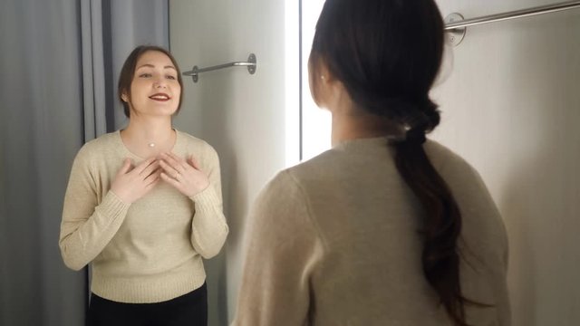 brunette girl measures the clothes in a fitting room