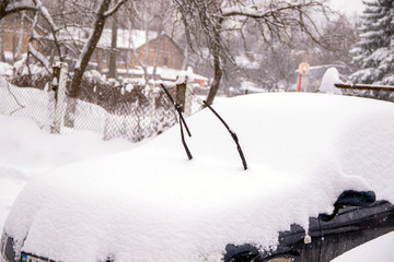 Snow-covered car with raised glass brushes for heavy snowfalls