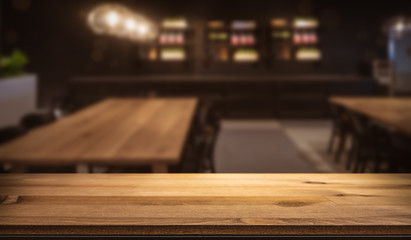 Wooden bar counter in front of cozy blurred pub restaurant. Table top for product display montage....