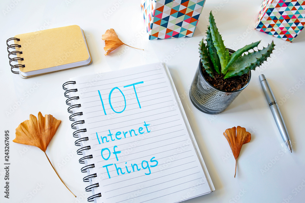 Aufkleber iot internet of things written in a notebook on white table
