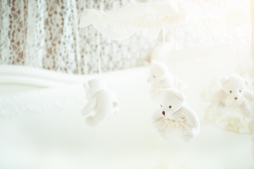 Fototapeta na wymiar White baby cot for newborn with hanging bears