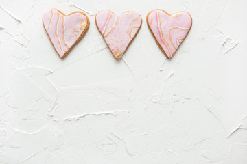 Obraz premium Three cookies in the shape of marble white hearts on wooden background