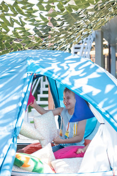 Portrait of cute boy inside tent at backyard