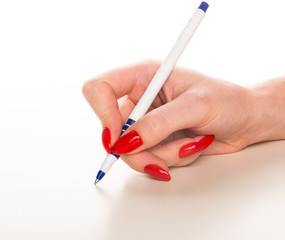 Beautiful female hand with red nails write with pen