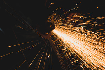 Industrial worker with an angle grinder at the factory