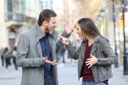 Angry couple arguing in the street