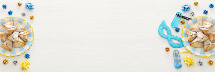 Purim celebration concept (jewish carnival holiday) over wooden white background.