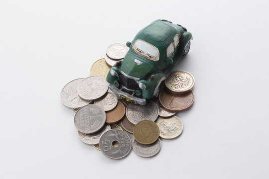 Stack of coins with old toy car