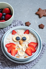 Kids breakfast oatmeal porridge with fruits and nuts