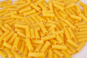 Raw pasta background. Uncooked pasta tubules background. Food background a pile of  pasta tubules. Top view