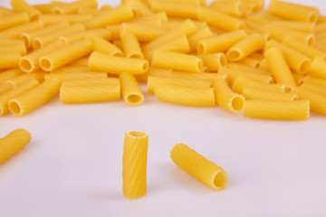 Raw pasta background. Uncooked pasta tubules background. Food background a pile of  pasta tubules. Top view