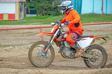 Fototapeta na wymiar Professional Motocross Motorcycle Rider Drives Over the Road Track.