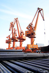 Fototapeta na wymiar portal crane and pipes on the shipping dock