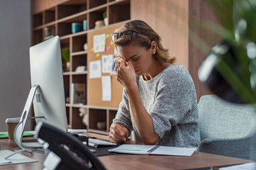 Business woman having headache at office - obrazy, fototapety, plakaty