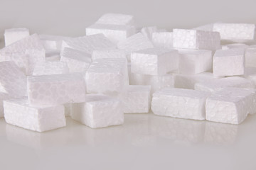 Filler packing background. Packaging foam pellets texture, top view, close-up. Polystyrene, white styrofoam packing peanuts used to prevent damage to fragile objects during shipping.