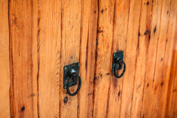 wooden gate with black iron handles. close up view.