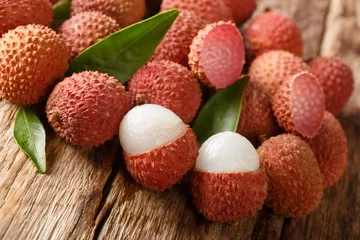 Fotobehang fresh organic lychee fruit on wood background. horizontal © FomaA