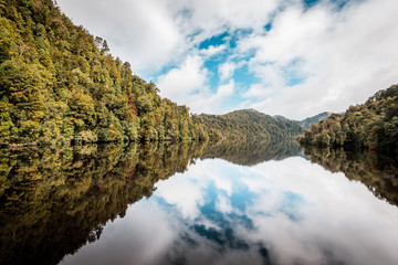 Natural reflections, mirror effect on the water in the beautiful wilderness of Tasmania, Gordon River near Strahan, Australia