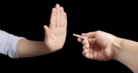 Hand refusing a cigarette offer, isolated on black background