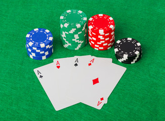 Casino chips and playing cards on green table