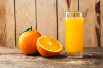 Orange juice and orange slices on wooden table