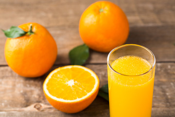 Orange juice and orange slices on wooden table