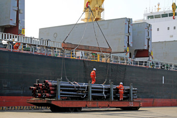 Crane hoisting steel pipe in the terminal yard, tianjin port, tianjin, China.
