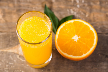 Closeup of orange juice in a glass with half of orange