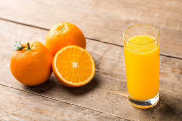 Orange juice and orange slices on wooden table