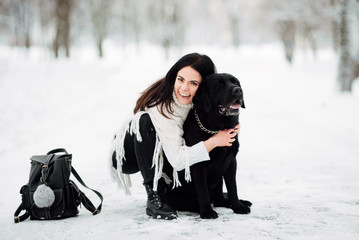 beautiful young girl with black hair in white jacket in winter resting outdoors,  woman playing...