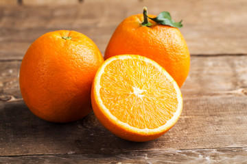 Closeup of oranges with sliced orange on table