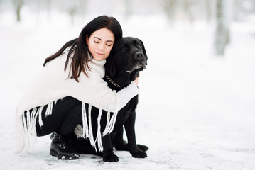 beautiful young girl with black hair in white jacket in winter resting outdoors,  woman playing...
