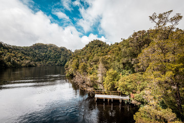 Obraz premium Tasmania, Australia on an Idyllic morning on the Gordon River, we'll take a cruise with great scenery and beautiful reflections in the water near the town of Strahan, on board of a highspeed catamaran