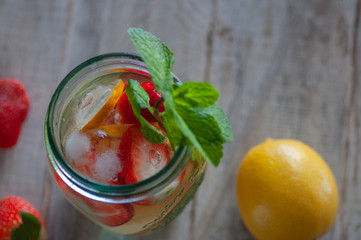fresh strawberry and lemon drink. Mint decorated. Located on a wooden swan table.