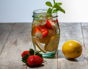 fresh strawberry and lemon drink. Mint decorated. Located on a wooden swan table.