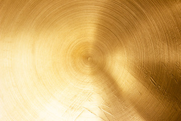 Fototapeta premium Abstract Gold polished metal brushed background or Shiny yellow leaf gold steel texture. Brushed metal plate with reflected light golden.
