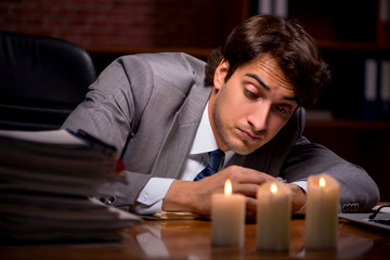Obraz premium Businessman working late in office with candle light