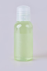 Hotel green bathroom shampoo, shower gel, lotion in a small transparent bottle isolated on a white background. Toiletries, 30 ml. Miniature shampoo bottle