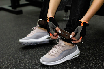  Close up front view of woman's hands tying shoelaces on sneakers in the gym. girl tying shoelaces on sneakers.