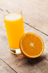Fresh orange juice with slice of fresh orange on wooden table