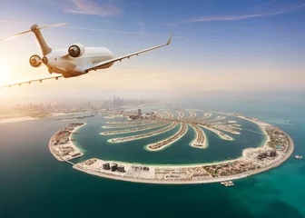 Foto auf Acrylglas Dubai Privates Jet-Flugzeug, das über Dubai-Stadt fliegt