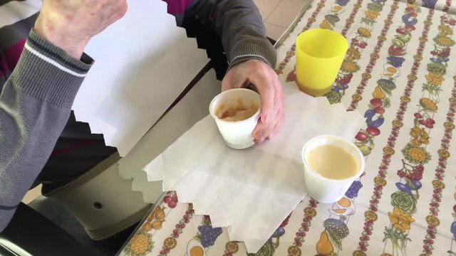 anziano su sedia a rotelle in casa di riposo che mangia